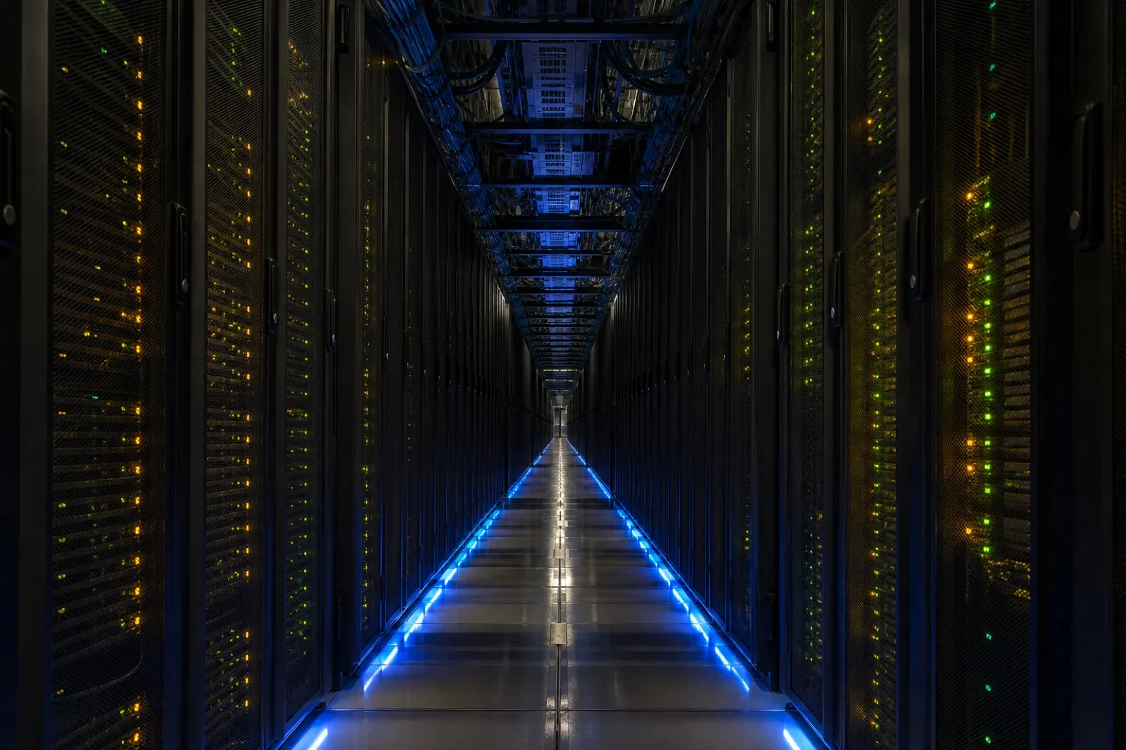 巨大なデータセンターのサーバーラックが奥まで並ぶ通路