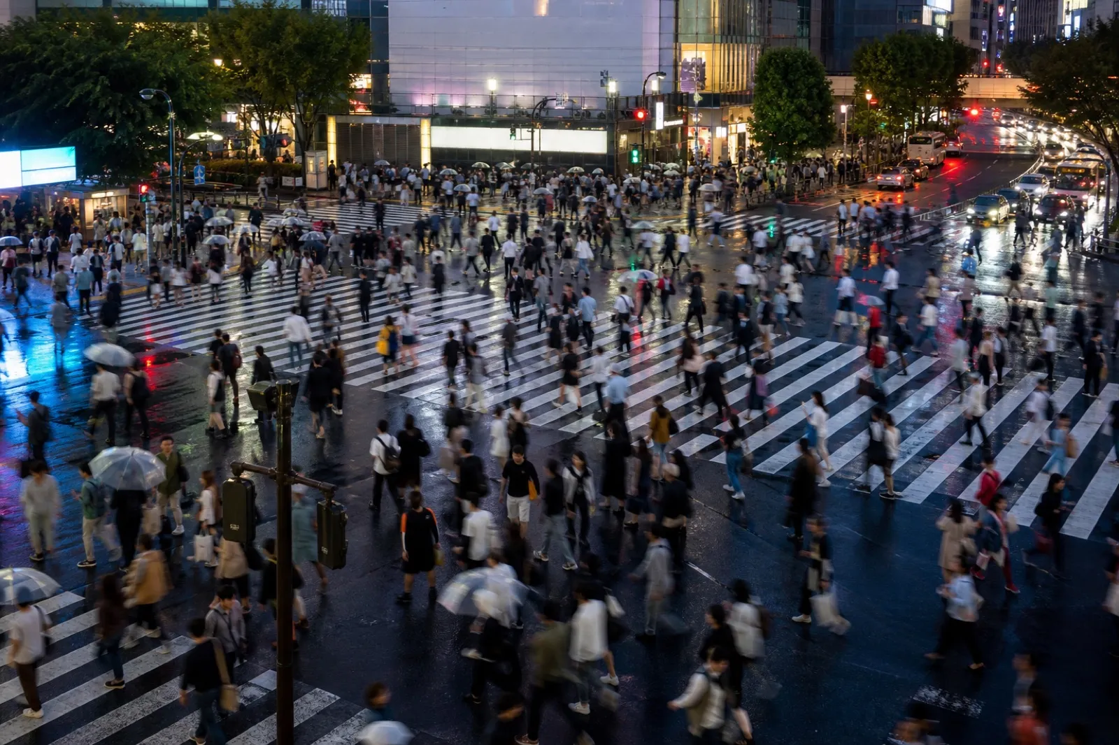 夕暮れのスクランブル交差点を行き交う人々。運が人のつながりを経由して届くことを表す